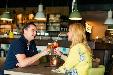Paar genießt einen Drink im Restaurant des Ferienparks Topparken Résidence Valkenburg