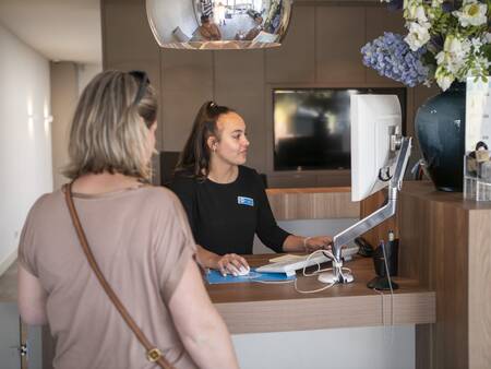 Frau an der Rezeption des Ferienparks Topparken Résidence Valkenburg