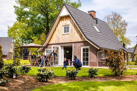 Familie im Garten eines freistehenden Ferienhauses im Ferienpark Villapark Hof van Salland