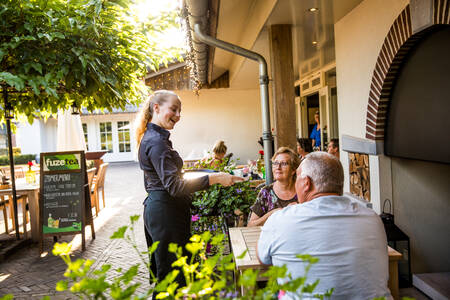 Menschen auf der Terrasse des Restaurants De Hazelaer im Villapark Hof van Salland