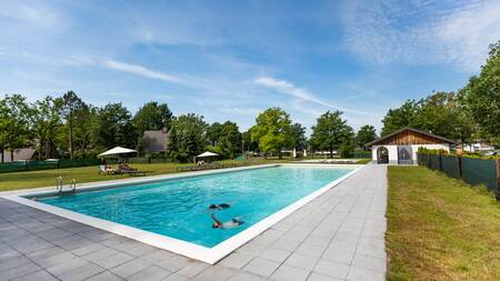 Menschen schwimmen im Außenpool des Ferienparks Villapark Hof van Salland