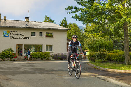 Mann radelt vor der Rezeption des Ferienparks RCN Belledonne